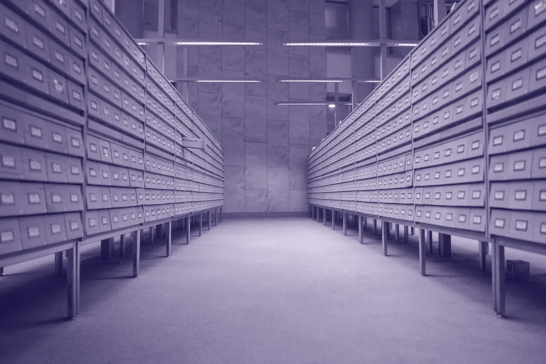 Reihen beschrifteter Archivkästen in einem Aktenlager